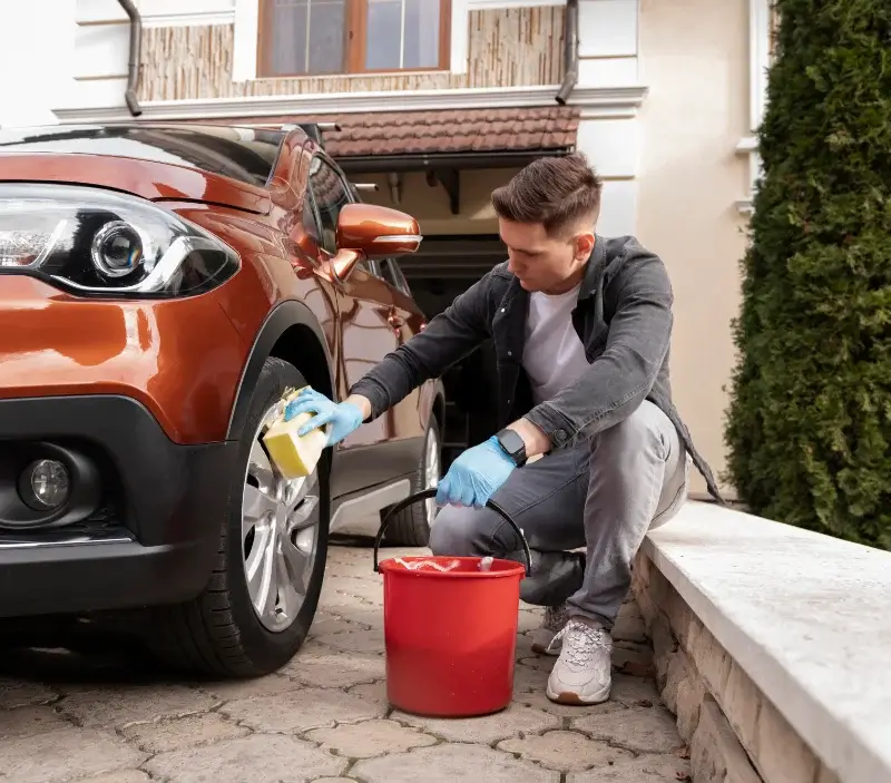 Lavage auto à domicile Les Trois-Pierres : professionnel intervenant sur un véhicule